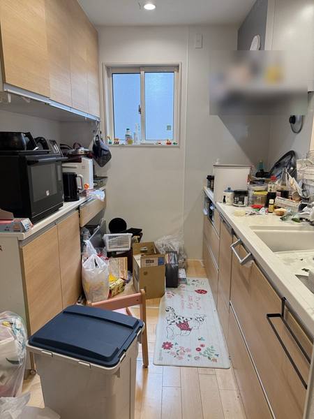 片付ける前のキッチン。調理台や床にものや袋があふれている