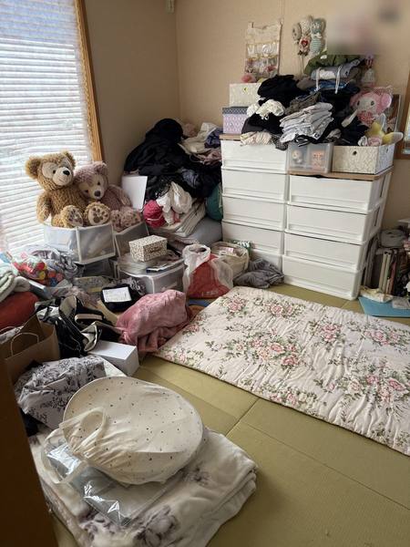 片付ける前の和室。衣類やぬいぐるみ、袋などが畳の上にあふれている